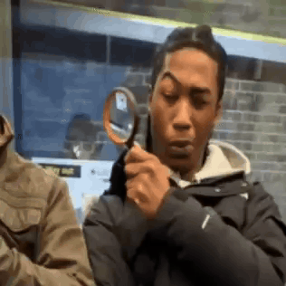 a man is holding a magnifying glass and looking through it.