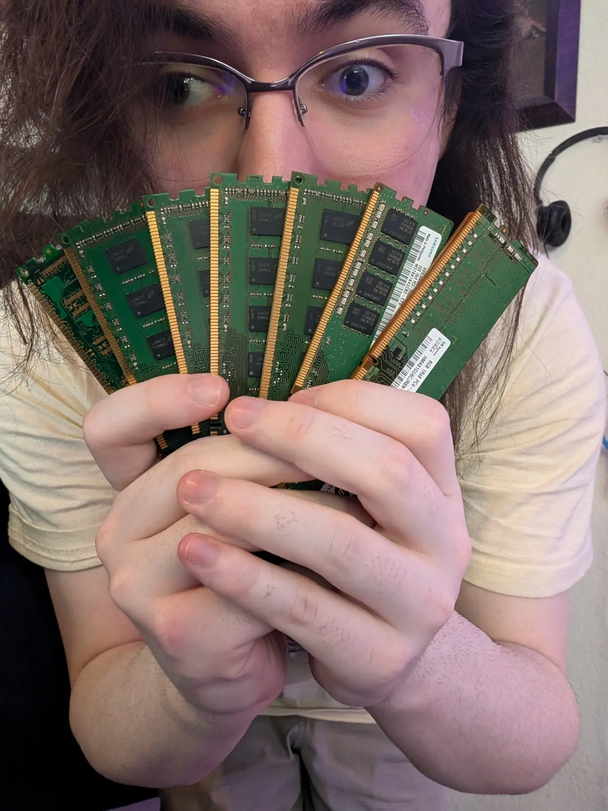 photo of me looking towards the camera while i'm holding a stack of random assortment of memory i found